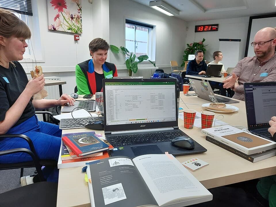 Students working together on laptops at a hackathon table