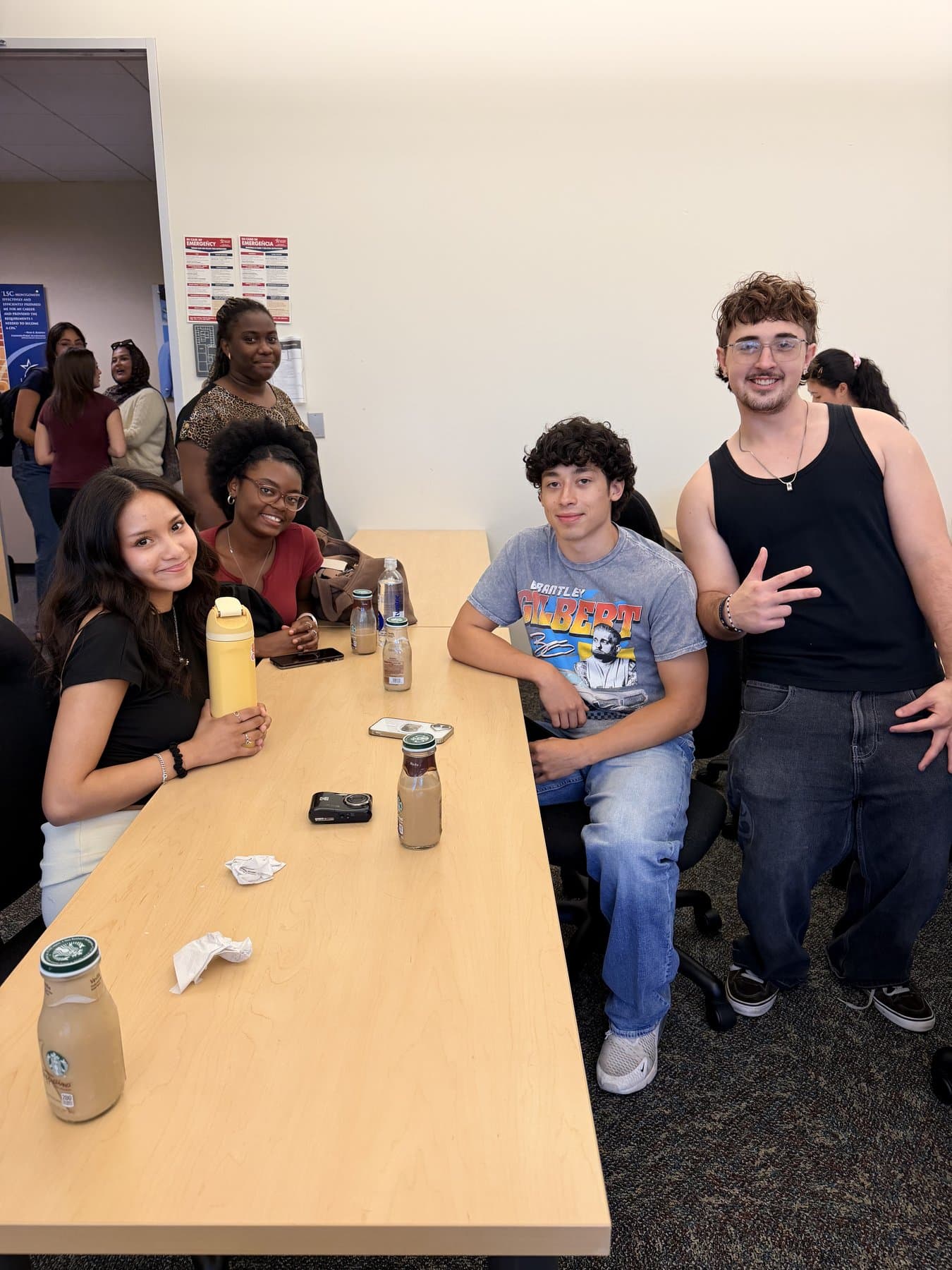 We Glue students hanging out around a table with drinks
